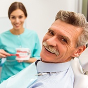 Man with dentures smiling during dentist's appointment