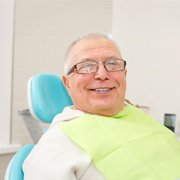 Senior man with glasses sitting in dental chair
