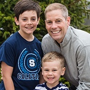 Dentist smiling with two younger dental patients