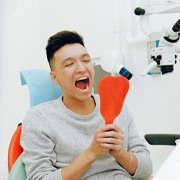 Man at dentist looking in mirror