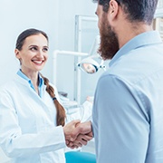 Patient shaking hands with his emergency dentist