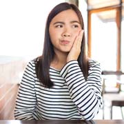 Woman with toothache in Cleveland sitting in a café