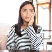 Woman with toothache in Cleveland sitting in a café