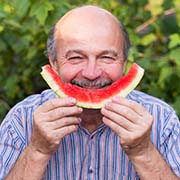 Man eating watermelon to prevent dental emergencies in Pepper Pike