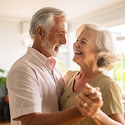 An older couple holding hands in the living room