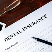 Dental insurance paperwork with X-rays and glasses