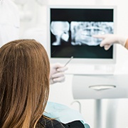 Dentist and patient looking at digital x-rays