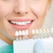 Dentist measuring color of patient’s teeth  