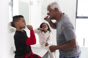 grandpa and grandchildren brushing together