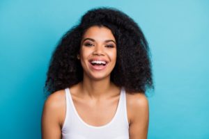 young woman smiling after seeing cosmetic dentist in Pepper Pike