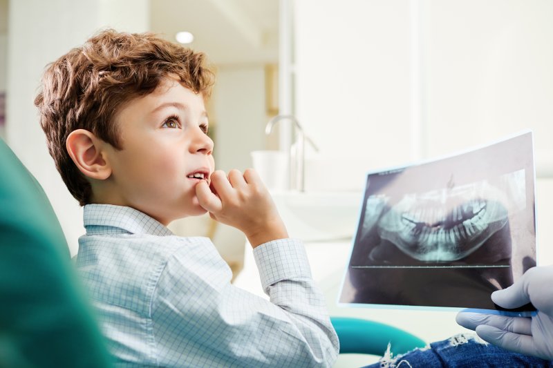 Child looking at dentist and dental X-ray