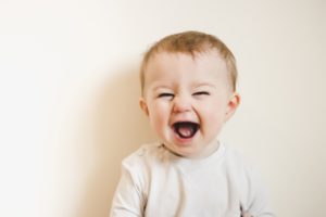 Happy baby laughing after successful tongue tie treatment