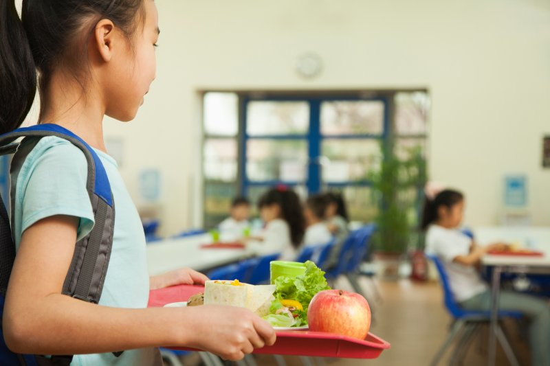 child holding food tray for school lunch in Cleveland