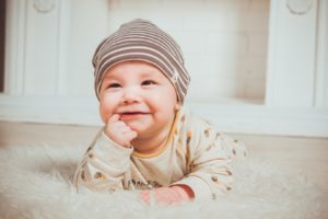 Smiling baby sucking on finger