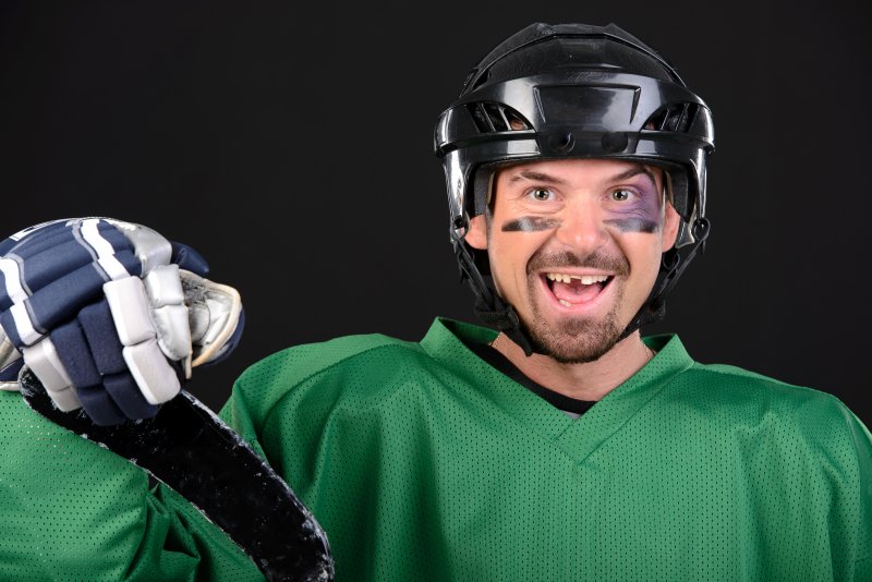 smiling hockey player that is missing a tooth