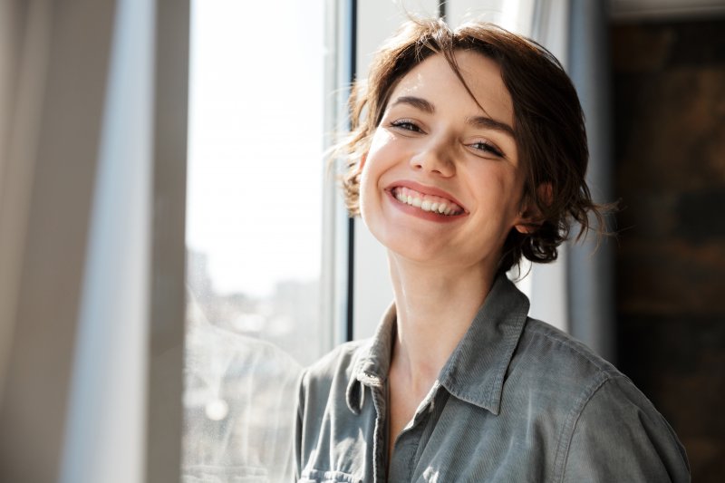 Woman smiling with her new dental crowns